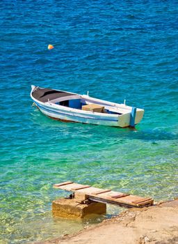 Old wooden fishermen boat on turquoise beach, Mediterranean sea