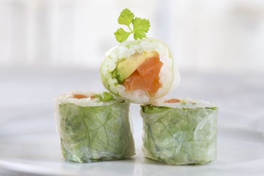 Delicious sushi rolls on white plate with chopsticks and wasabi