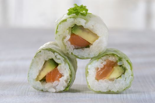 Delicious sushi rolls on white plate with chopsticks and wasabi