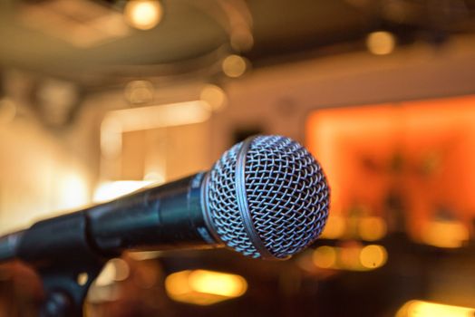 Closeup of audio microphone on stage background