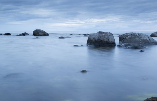 Calm Ocean with Rocks and blue ocean and sky.