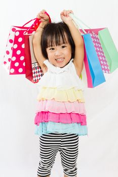 Asian Chinese little girl with shopping bag in white isolated background.