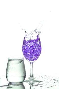 Stemmed champagne glass with liquor splashing out, isolated on white background