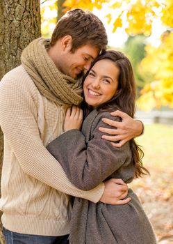 love, relationship, family and people concept - smiling couple hugging in autumn park