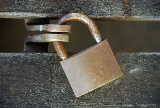 Strong padlock closing a wooden door