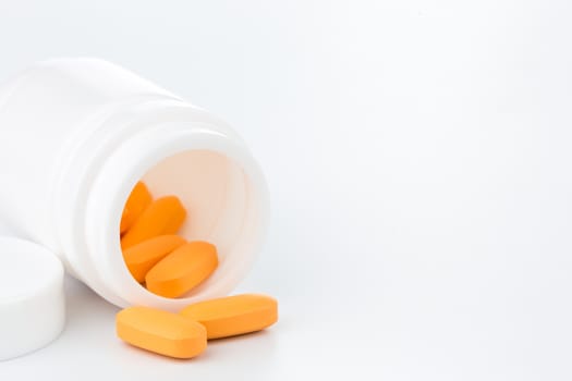 orange pills an pill bottle on white background (Isolated)