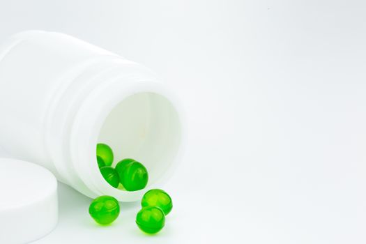 green gel pills an pill bottle on white background (Isolated)