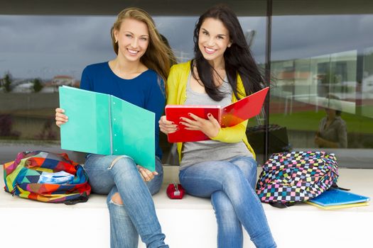 Beautiful and happy teenage students studying together in the school