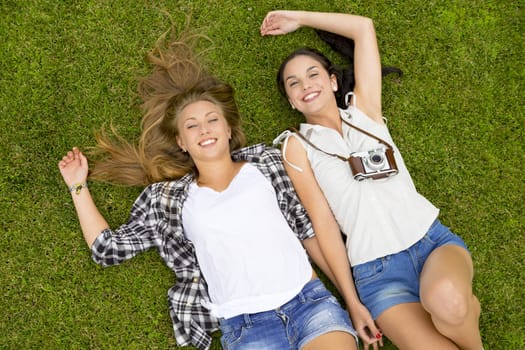 Female best Friends lying on the grass and having a good time together