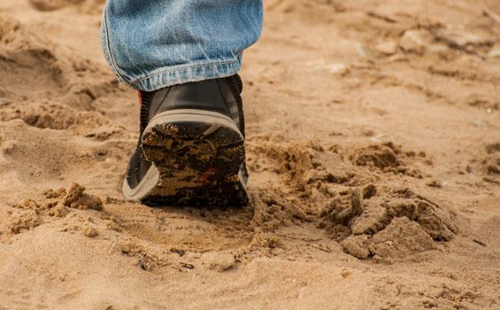 Human walking outdoors on a sandy shore