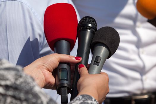 Broadcast journalism. Reporters taking interview at news conference.