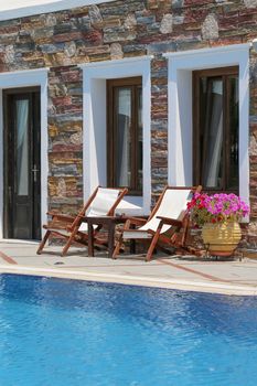 Chaise lounge around swimming pool at a sunny day