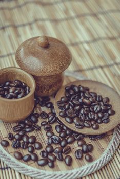 Coffee beans and coffee cup set on bamboo wooden background.Photo in retro color image style, Soft focus.