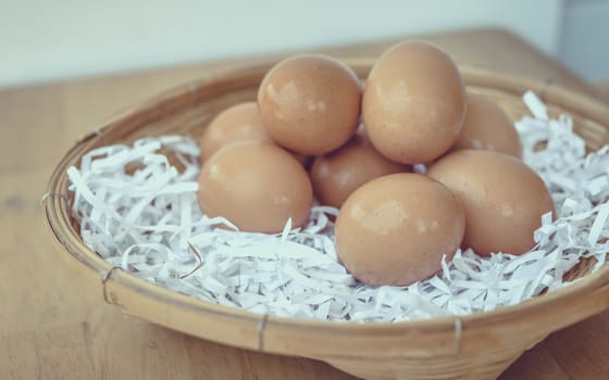 Eggs in a wicker basket on a wooden table