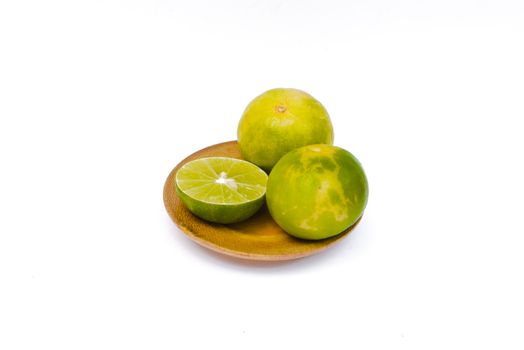 Lime placed in wooden tray on white background.