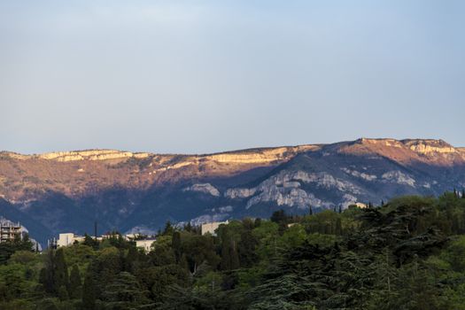 Mountains by the sea in beams of a bright sun