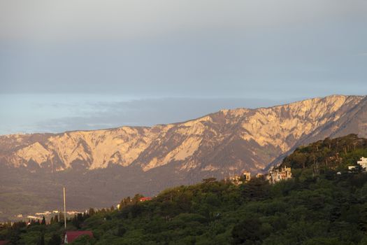 Mountains by the sea in beams of a bright sun