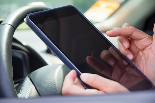 close up of Woman Sitting in the Car and Using digital tablet