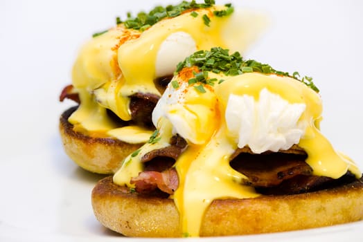 Eggs Benedict on toasted muffins with bacon and sauce