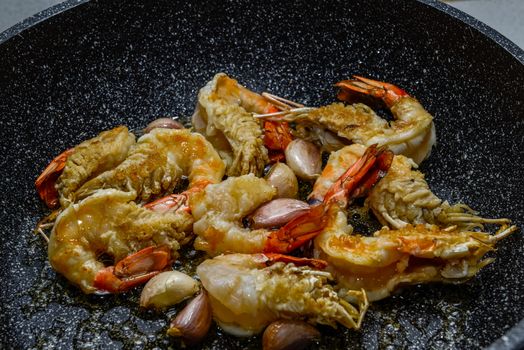 Closeup of shrimps on pan with fresh herbs