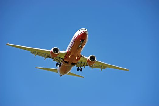 Red and White Passenger aircraft landing in Mallorca with tourists