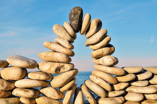 Arc of pebbles between of the stones on the seashore