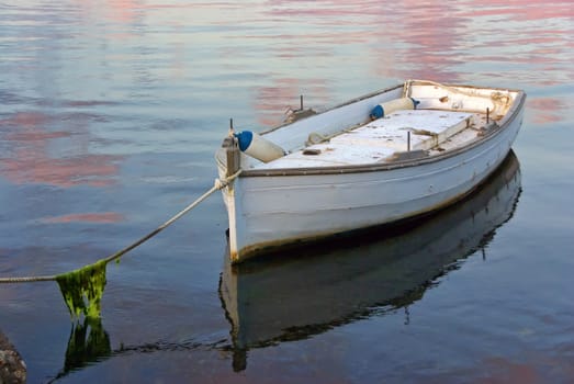 A lonely white boat tied with a rope