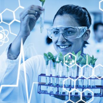 Science graphic against female scientist analyzing young plants at lab