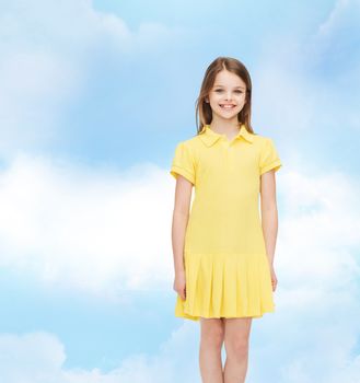 happiness, childhood and people concept - smiling little girl in yellow dress