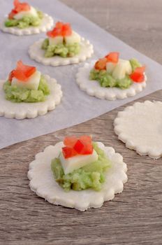 Stuffed avocado with cheese and tomato on a slice of puff pastry