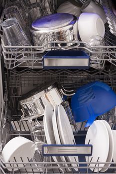 Dishwasher loades in a kitchen with clean dishes and blue light