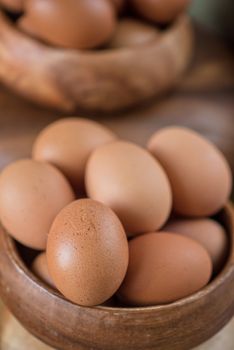 Fresh eggs at wooden plate closeup