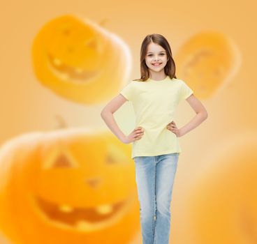holidays, childhood, happiness and people concept - smiling little girl over halloween pumpkins background