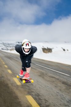 Downhill skateboarder in action on a asphalt road.