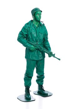 Man on a green toy soldier costume with riffle isolated on white background.