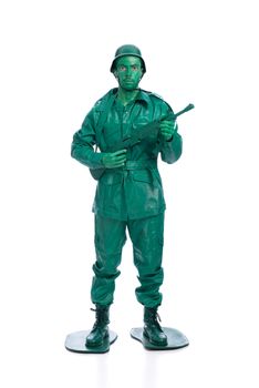 Man on a green toy soldier costume with riffle isolated on white background.