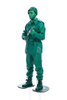 Man on a green toy soldier costume with riffle isolated on white background.