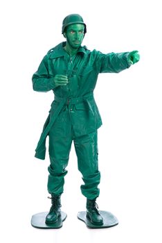 Man on a green toy soldier costume with riffle poiting with his forefinger  isolated on white background.