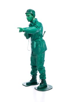 Man on a green toy soldier costume with riffle poiting with his forefinger  isolated on white background.