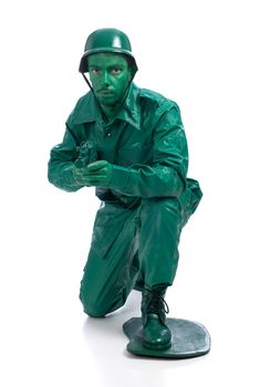 Man on a green toy soldier costume standing on one knee with riffle isolated on white background.