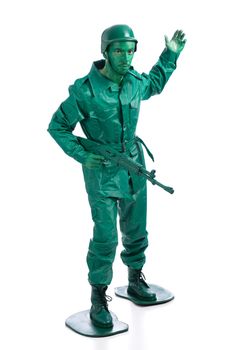 Man on a green toy soldier costume with riffle waving to be followed  isolated on white background.