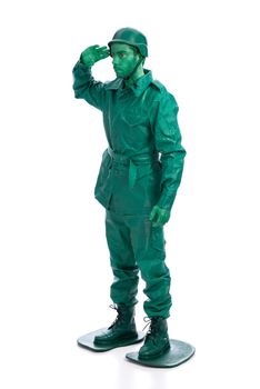 Man on a green toy soldier costume saluting isolated on white background.