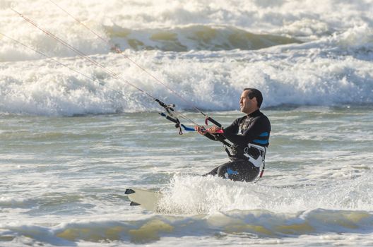 Kitesurfer in action on a beautiful background of spray during the sunset.