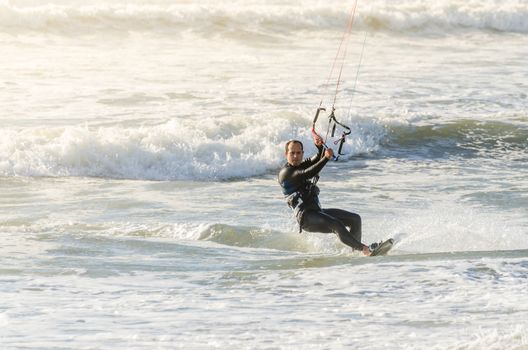 Kitesurfer in action on a beautiful background of spray during the sunset.