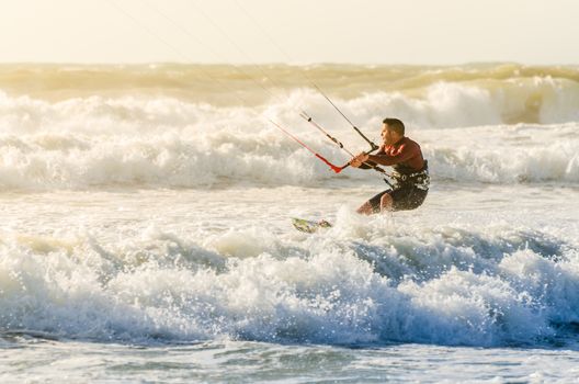 Kitesurfer in action on a beautiful background of spray during the sunset.