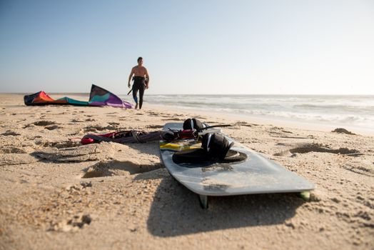 Kitesurfer prepating his equipment on a beautiful sunset at the beach.