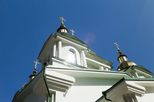 Orthodox church in beams of a bright sun against the blue sky