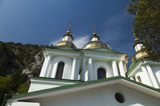 Orthodox church in beams of a bright sun against the blue sky