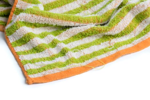 A close up of a colorful towel with loose, frayed threads on a white background.
