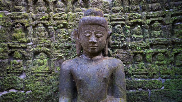 Buddha image with relief in the background at the Koe-thaung Temple, the temple of the 90,000 Buddhas, built by King Min Dikkha during the years 1554-1556 in Mrauk U, Rakhine State in Myanmar.